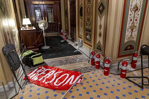 A flag that reads 'Treason' is visible on the ground in the early morning hours of Thursday, Jan. 7, 2021, after protesters stormed the Capitol in Washington, on Wednesday. (Photo | AP)