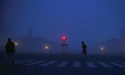 A jogger crosses the Vijay Chowk early in the morning as fog covers Rajpath in New Delhi. (File Photo | Shekhar Yadav, EPS)