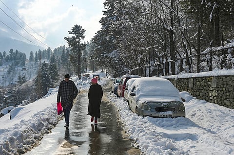 People walk down a road after fresh snowfall at Tangmarg in Baramulla District of north Kashmir. (File Photo | PTI)