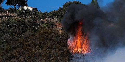 A wildfire burns near a home in Goleta, California. (Photo | AP)
