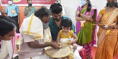 :Director Vijayakrishnan initiating a child into the world of letters on the occasion of Vijaya Dashami at a function held at Thunjan Smaraka Samiti Iranimuttom. (Photo | BP Deepu, EPS)