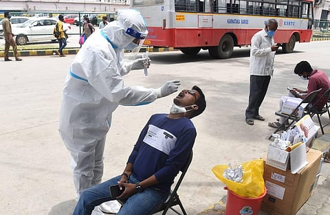 A health worker tests a person for coronavirus at the KSRTC BUs terminal in Bengaluru on Monday. (Photo | Vinod Kumar T, EPS)