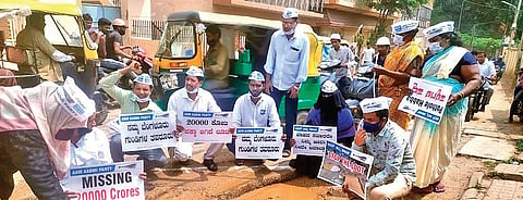 Citizens, along with AAP members, protest against the bad condition of roads by performing puja to huge potholes on various streets on Wednesday