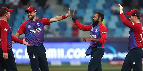 England's Adil Rashid is congratulated by teammates after taking the wicket of West Indies' Obed McCoy during the T20 World Cup match at the Dubai International Cricket Stadium. (Photo | AP)