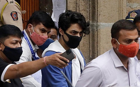 Aryan Khan, center, escorted by law enforcement officials from Narcotics Control Bureau office is being taken for a medical check up, in Mumbai. (Photo | AP)