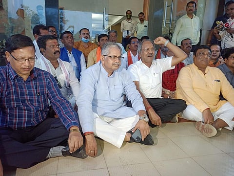 Opposition BJP leaders sitting on dharna outside the circuit house in Kawardha district after they were denied permission by the administration to visit the town Oct 7. (Photo | Special arrangement)