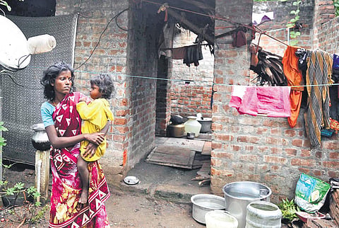 A tribal woman with her child standing in front of her half-constructed house at Thizukuzangundram in Chengalpet district | DEBADATTA MALLICK