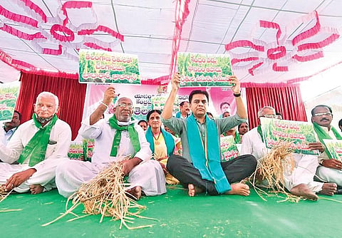 TRS working president KT Rama Rao and party workers hold up placards as they stage a dharna in Siricilla demanding that the Centre procure paddy produced in Telangana, on Friday