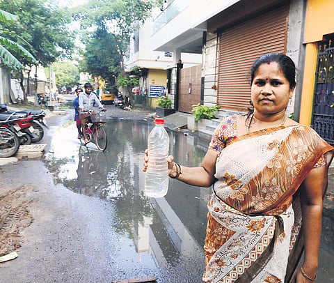 A woman holds a bottle of Metro Water mixed with sewage coming out of taps at Jawahar Street at Kodungaiyur in Chennai on Sunday | DEBADATTA MALLICK