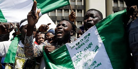 People hold banners as they demonstrate on the street to protest against police brutality, in Lagos, Nigeria. (Photo | AP)