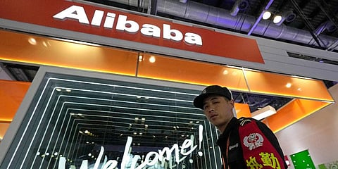 A security guard passes by the Alibaba booth at a trade show in Beijing, China, Tuesday, Sept. 7, 2021.
