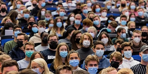 Students wear mouth-to-nose coverings while sitting close to each other during the lecture 'BWL 1' in lecture hall H1 of the Westfaelische Wilhelms-Universitaet in Muenster, Germany. (Photo | AP)