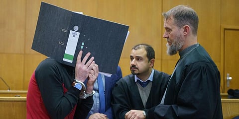With a file folder in front of his face, the Iraqi Taha Al-J. (L) talks to his lawyers Serkan Alkan (C) and Martin Heising before the sentencing in the Frankfurt Higher Regional Court. (Photo | AP)