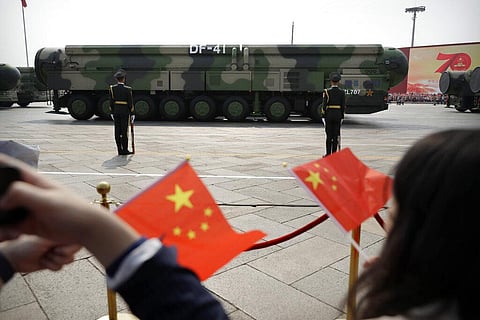 Spectators wave Chinese flags as military vehicles carrying DF-41 ballistic missiles roll during a parade to commemorate the 70th anniversary of the founding of Communist China. (Photo | AP)