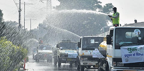 Water being sprayed on the road even as a thick layer of smog engulfed Delhi for the seconed day after Diwali. (Photo | Shekhar Yadav, EPS)
