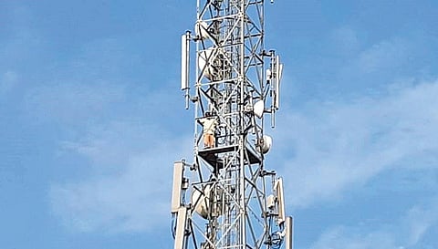 Farmer D Sampath stands on top of a cell tower at Devaruppula mandal in Jangaon, seeking action against those trying to grab his land, on Tuesday, Nov 30, 2021.