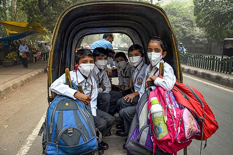 Students wearing masks to get protection from air-pollution go to their school by a rickshaw. (File | PTI)