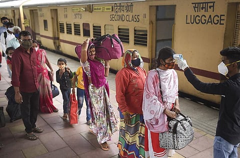A health worker checks body temperature of passengers as a precaution against the coronavirus, at Dadar Railway Station in Mumbai, Tuesday, Nov. 30, 2021. (Representational hoto | PTI)