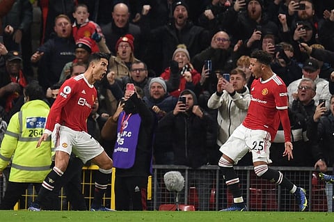 Manchester United players Cristiano Ronaldo (L) and Jadon Sancho (R) celebrate after a goal during EPL match against Arsenal at Old Trafford in Manchester, England, on Dec 2, 2021. (Photo | AFP)