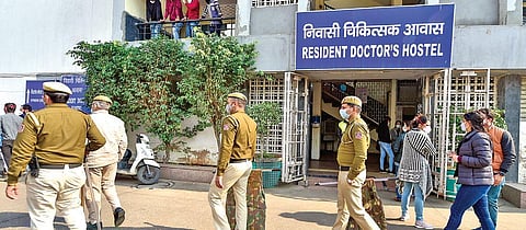 Police stand guard as resident doctors stage a protest outside a hostel of Safdarjung Hospital in Delhi on Wednesday. (Photo | PTI)