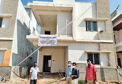 The staff and officials of Dundigal Municipality caution buyers through banners after sealing the unauthorised villas, in Mallampet on Saturday.