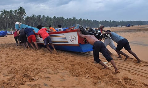 File photo of fishermen at Poonthura coast in Thiruvananthapuram shift their boats to a safe zone. (Photo | B P Deepu, EPS)