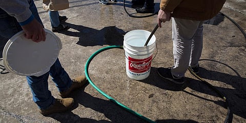 Residents fill up containers at the water station at the New Braunfels Civic/Convention Center in New Braunfels, Texas. (Photo| AP)