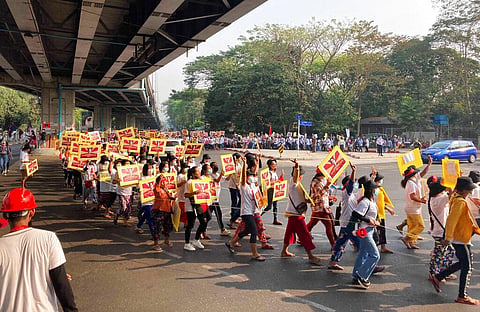 Anti-coup protesters holding posters of deposed Myanmar leader Aung San Suu Kyi march outside the Hledan Centre in Yangon, Myanmar. (Photo | AP)