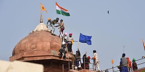 Farmers post flags on a dome of Red Fort after their tractor parade on Republic Day, in New Delhi. (Photo | PTI)