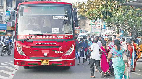 Passengers rush into a bus at the DMS bus stop in Chennai on Thursday | Sri Loganathan V