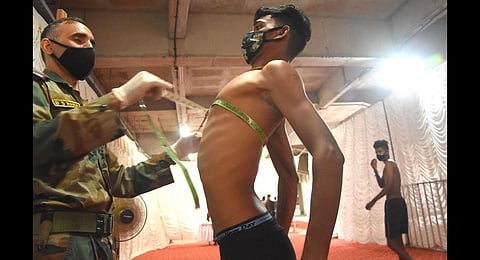 An army official takes the chest measurement of a candidate in the army recruitment rally being held at Greenfield Stadium. (Photo | B P Deepu, EPS)