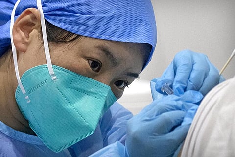 In this Jan. 15, 2021, file photo, a medical worker gives a coronavirus vaccine shot to a patient at a vaccination facility in Beijing. (Photo | AP)