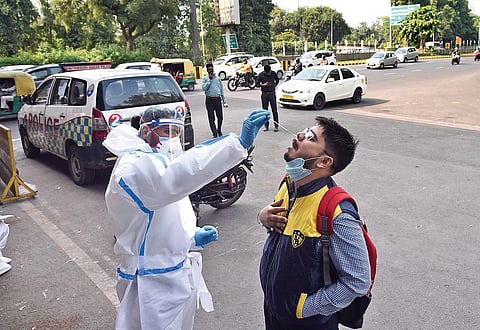A communter undergoes a traditional Covid test in Noida. (Photo | Parveen Negi, EPS)