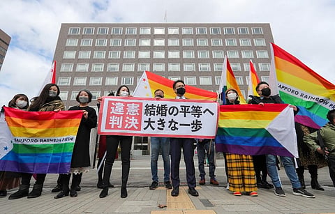 Supporters hold the 'unconstitutional decision' flag as they are pleased with the Sapporo District Court's decision that it is unconstitutional to not allow same-sex marriage in Sapporo. (Photo | AFP)
