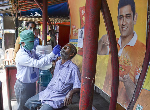 A medic takes swab sample from a person for COVID-19 test amid surge in coronavirus cases, in Thane, Sunday. (Photo | PTI)