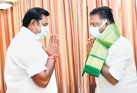 Chief Minister Edappadi K Palaniswami greeting Deputy Chief Minister O Panneerselvam at a hotel in Salem city on Wednesday morning; (below) an AIADMK supporter on the streets of Mylapore in Chennai |