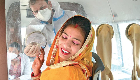 A HCW tries to take a swab sample from a woman for Covid test in Amritsar | pti