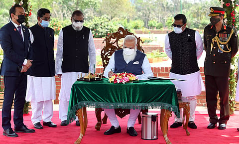 Prime Minister Narendra Modi signs the visitors' book at National Martyrs' Memorial, Savar in Dhaka on Friday. (Photo | ANI)