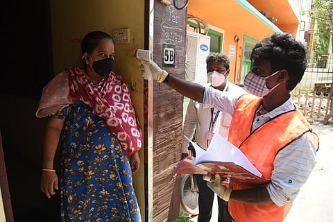 A healthcare worker conducts thermal screening on a woman. (Photo | R Satish Babu, EPS)