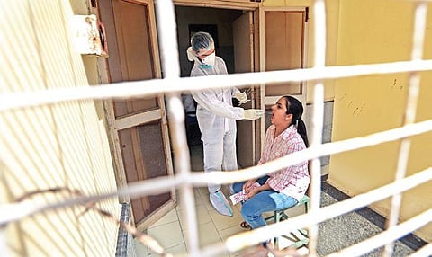 A health workers takes swab sample for Covid testing. (Photo | Shekhar Yadav)