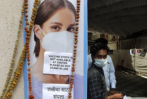A volunteer waits outside a vaccination center which has been closed because of shortage of the COVID-19 vaccine in Mumbai. (Photo | AP)