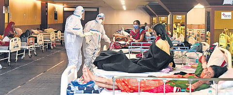Doctors wearing Personal Protective Equipment (PPE) kits examine patients inside a Covid-19 care centre and an isolation ward facility near a hospital | Parveen Negi