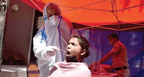 A medic takes swab sample of a women for testing on Wednesday | shekhar yadav