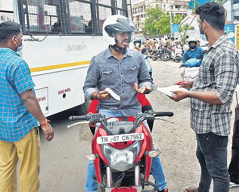 Chennai Corporation staff collecting fine from a person for not wearing mask on Velachery High Road on Thursday | Ashwin prasath