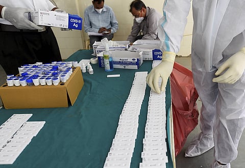 A health worker sorts swab samples at a testing centre, as coronavirus cases surge across the national capital, at MCD dispensary, Mehrauli, in New Delhi. (Photo | PTI)