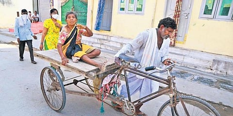 An elderly woman arrives at a polling booth on a cart to exercise her franchise. (Photo | EPS)