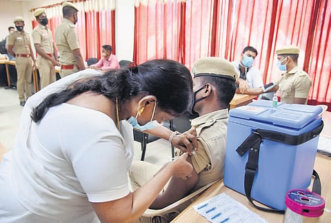 A policeman getting vaccinated at Rajarathinam Stadium, in Chennai, on Monday. (Photo | R Satish Babu/EPS)