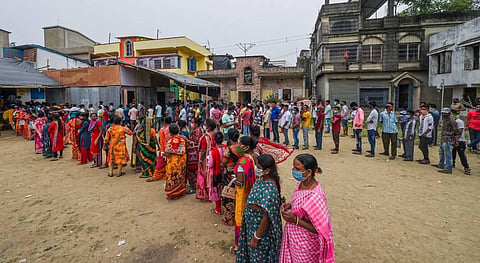 People seen standing in a queue to cast their votes at a polling station . (File Photo | PTI)