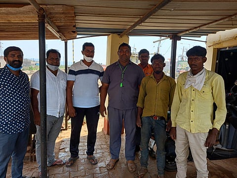 Two workers (in yellow shirts on the right) along with local activists who arranged their safe journey back home. (Photo | Special arrangement)