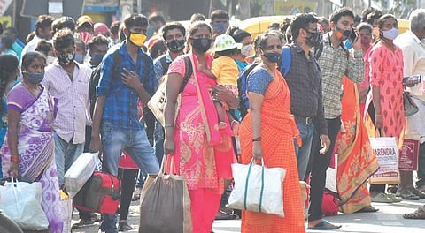 People wait to board buses on Tumakuru Road to reach their hometowns, ahead of the corona curfew in Bengaluru on Monday | VINOD KUMAR T